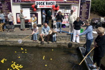 Traditional Duck Race in The Lower Pleasure Gardens with tourists watching and participating