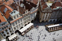 Restaurant and cafe tables with strolling pedestrians in the Old Town Square