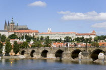 View across the Vtlava River to Charles Bridge with St Vitus cathedral in Prague Castle on the hilltop