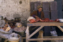 Female vendor with yak meat for sale in Jokhang market.