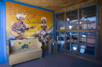 Happy Trails local arts and crafts shop and its front wall painted with a picture of a cowgirl and a cowboy playing a guitar