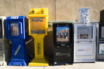 Newspaper and real estate vending machines on the pavement