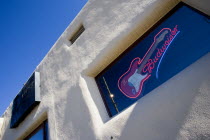 Illuminated Budweiser sign and electric guitar in window of Blues Club