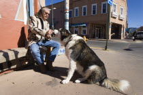 Native American man feeding his dog outside Father Sky Mother Earth Native American arts and crafts gallery on Water Street
