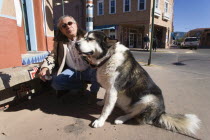 Native American man feeding his dog outside Father Sky Mother Earth Native American arts and crafts gallery on Water Street