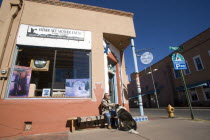 Native American man feeding his dog outside Father Sky Mother Earth Native American arts and crafts gallery on Water Street