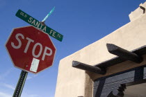 Stop sign on the Old Santa Fe Trail beside and adobe Pueblo Revival style building