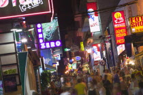 Busy  crowded street in Sant Antonio with neon signs advertising food and clubs.HolidaysTourismLeisureBarsDrinking