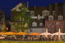 Rows of floodlit bars  people sat at outside tables with large parasols.TourismHolidaysTravelBaltic States