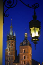 Detail of St Marys Church in Rynek Glowny  Night time with lit lamp with decorative bracket on wall.Eastern EuropeHolidaysTravelTourism