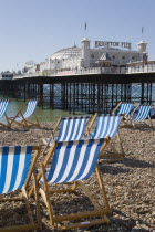Brighton Pier with empty deckchairs on the beach in the foreground