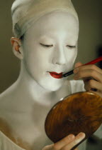 Kabuki actor applying make up.  Female actors are banned as immoral and their roles taken by male onnagata or female role specialists.