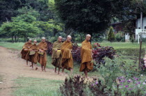 Young Buddhist monks on morning round to collect food alms near Fang.