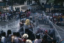 Buddhist Water Festival.  Crowds spraying water from open topped jeep. Burma