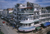 City view over converging streets  one well maintained and the other partly destroyed after the Khmer Rouge regime.  Both lined with shops with apartments above