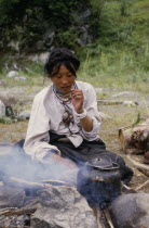 Tibetan woman boiling tea on the roadside.