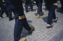 Parade of people wearing golden Clogs in Steenstraat during Braderie festival Flemish Region