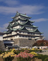 The Castle with floral gardens in the foreground and small cabin with tables and chairs outside.