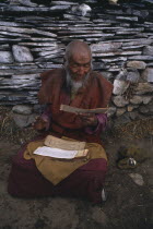 Elderly man reciting mantras at sky burial