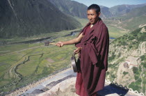 Monk calling others to prayer with drum.
