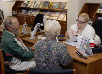 Male and female customer in a Travel Agents office discussing their holiday arrangements with a female travel consultantEuropean Great Britain Northern Europe UK United Kingdom British Isles