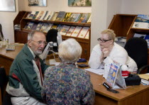 Male and female customer in a Travel Agents office discussing their holiday arrangements with a female travel consultantEuropean Great Britain Northern Europe UK United Kingdom British Isles