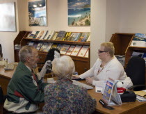 Male and female customer in a Travel Agents office discussing their holiday arrangements with a female travel consultantEuropean Great Britain Northern Europe UK United Kingdom British Isles