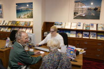 Male and female customer in a Travel Agents office discussing their holiday arrangements with a female travel consultantEuropean Great Britain Northern Europe UK United Kingdom