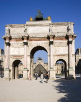 People walking from the Jardin des Tuileries through the Arc de Triomphe du Carrousel towards the pyramid entrance to the Musee du LouvreFrench Western Europe European