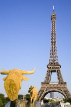 Gilded bronze water fountain statue of a cow and calf in the Trocadero Gardens with the Eiffel Towe in the diatanceFrench Western Europe European