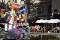 People sitting at tables under umbrellas beside the colourful contemporary fountains by Niki de Saint Phalle and Jean Tinguely in Place Igor Stravinsky beside the Pompidou Centre in Beauborg Les Halle...