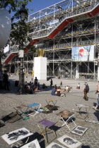 Tourists watching a street performer in the square outside the Pompidou Centre in Beauborg Les Halles with artists selling their work on the pavement in the foregroundFrench Western Europe European
