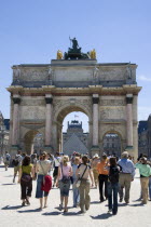 Tourists walking from the Jardin des Tuileries towards the Arc de Triomphe du Carrousel and the Musee du Louvre beyondFrench Western Europe European
