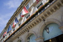 The five star Hotel Le Meurice in the Rue de Rivoli with red geraniums in window boxes on the balconies above the pavement arches beside flags of nations of the worldFrench Western Europe European