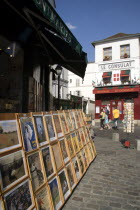 Montmartre Tourists walking past a shop selling prints of Impressionist paintings and posters beside Le Consulat RestaurantFrench Western Europe European