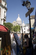 Montmartre Tourists walking past artists painting in Place du Tertre square beside the Church of Sacre CouerFrench Western Europe European