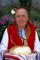 Dobarski Babi Folk Group  member of folk group holding bread on plate.TravelTourismHolidayVacationExploreRecreationLeisureSightseeingTouristAttractionTourDobarskoBanskoBulgariaBulgarian...