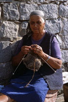 Old lady sitting on bench knitting.TravelTourismHolidayVacationAdventureExploreRecreationLeisureSightseeingTouristAttractionTourBanskoBulgariaBulgarianLadyWomanFemalePersonOldGran...