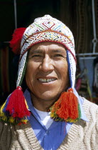 Peruvian man wearing colourful traditional hat with tassels  in Mercado del Quiswarcancha.Colorful TravelTourismHolidayVacationExploreRecreationLeisureSightseeingTouristAttractionTourDesti...