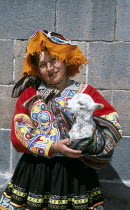 Lady wearing a colourful costume holding a lamb in her arms Colorful Cuzco TravelTourismHolidayVacationExploreRecreationLeisureSightseeingTouristAttractionTourDestinationCuscoCuzcoPeru...