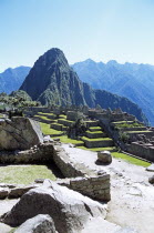 Inca ruins and Huayna Picchu  wall in foreground.Cuzco TravelTourismHolidayVacationExploreRecreationLeisureSightseeingTouristAttractionTourDestinationMachuPicchuMachupicchuHuaynaWayna...