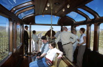 Passengers relaxing in observation carriage of Puno to Cusco Perurail train journey.Cuzco TravelTourismHolidayVacationExploreRecreationLeisureSightseeingTouristAttractionTourDestinationPu...