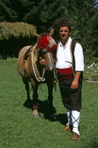 Man in national costume standing with horse. Pirin Mountain  near Bansko .Equestrian TravelTourismHolidayVacationExploreRecreationLeisureSightseeingTouristAttractionTourChalinValogBansk...