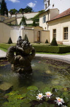 Fountain and water lillies set amonsgt trimmed box hedging and conifers at The Vrtba Gardens in the Little QuarterPraha Ceska Eastern Europe European