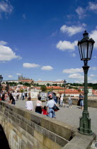 Tourists on the Charles Bridge across the Vltava River with Prague Castle and St Vitus Cathedral on the horizonPraha Ceska Eastern Europe European Religion Religious