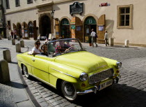 Tourists in a yellow convertible Skoda used for sightseeing tours around the Old TownPraha Ceska Eastern Europe European