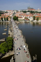 People walking across the Charles Bridge across the Vltava River towards the Little QuarterPraha Ceska Eastern Europe European
