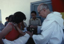 Priest pouring holy water over infants head  La Forestal  Bolivia.American Bolivian Hispanic Kids Latin America Latino Religious South America Religion