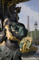 Ornate statues in a water fountain in the Place de la Concorde with the Eiffel Tower in the distance beyondEuropean French Western Europe