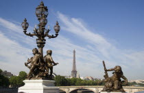Bronze statue of a cherub and an ornate lamp post on the Pont Alexandre III bridge across the River Seine with the Eiffel Tower in the distanceEuropean French Western Europe